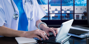Using minitab statistical software for the healthcare industry for reducing variability in critical processes; a doctor with a stethoscope at a computer