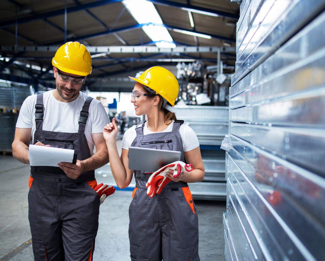 manufacturing; two workers with hard hats and overalls checking quality with Minitab